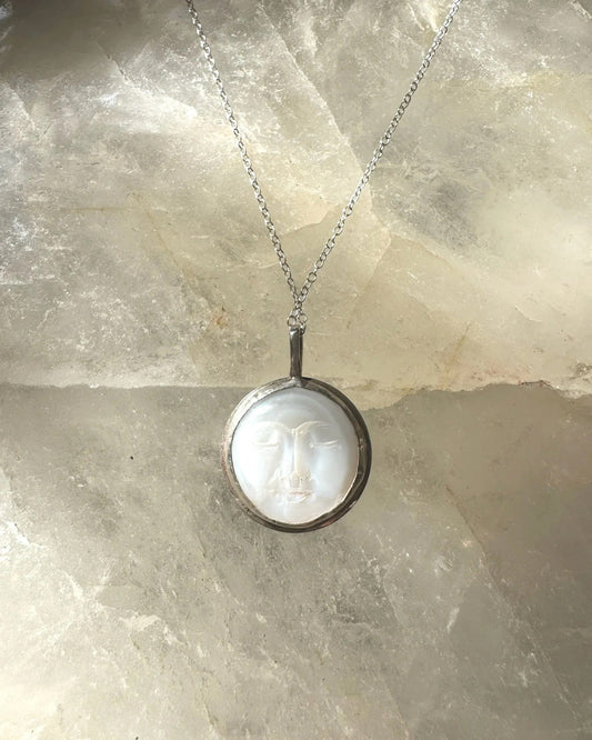 Necklace with a pendant on a textured stone surface